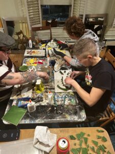 A group of people sitting at a table painting